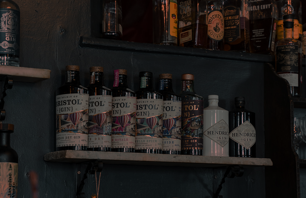 A shelf of Spirit of Bristol gin bottles behind the bar at The Milk Thistle