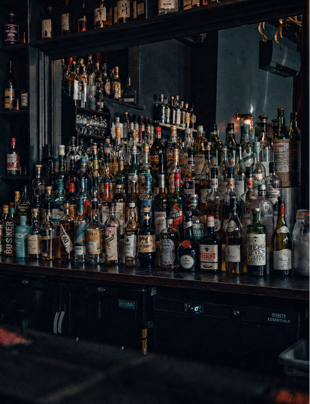 The Vault at The Milk Thistle, a dark back bar lined with rows of spirit bottles